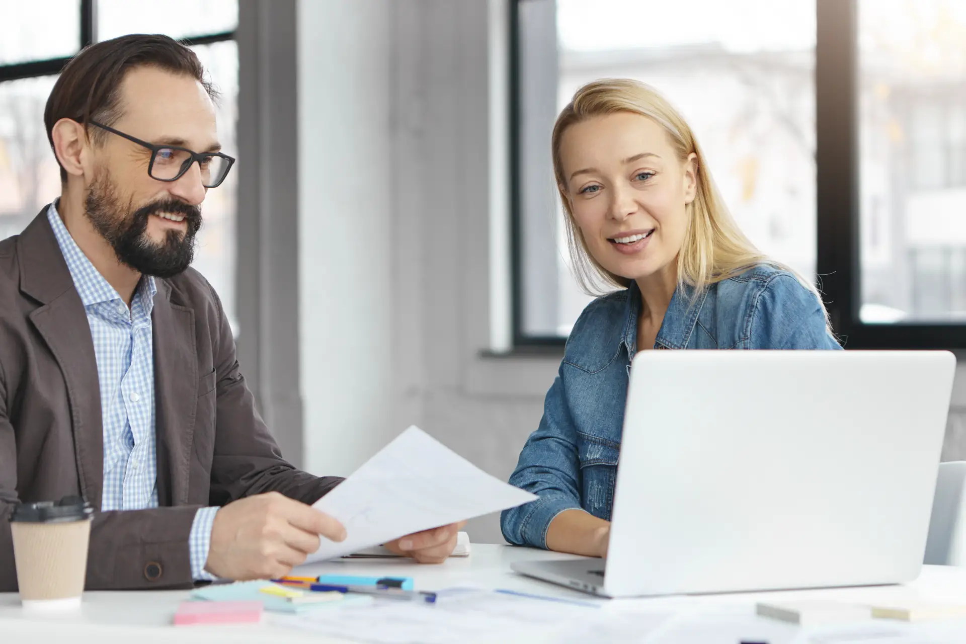 happy blonde female manager has conversation with male colleague