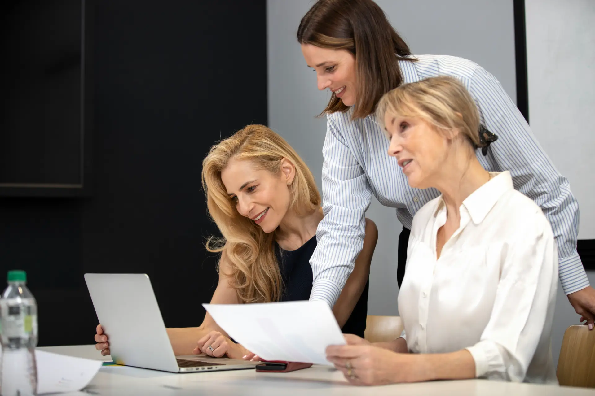 medium shot smiley women working with laptop