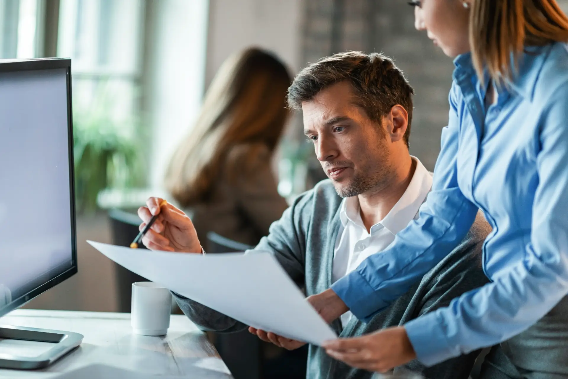 two business colleagues examining documents while working together office